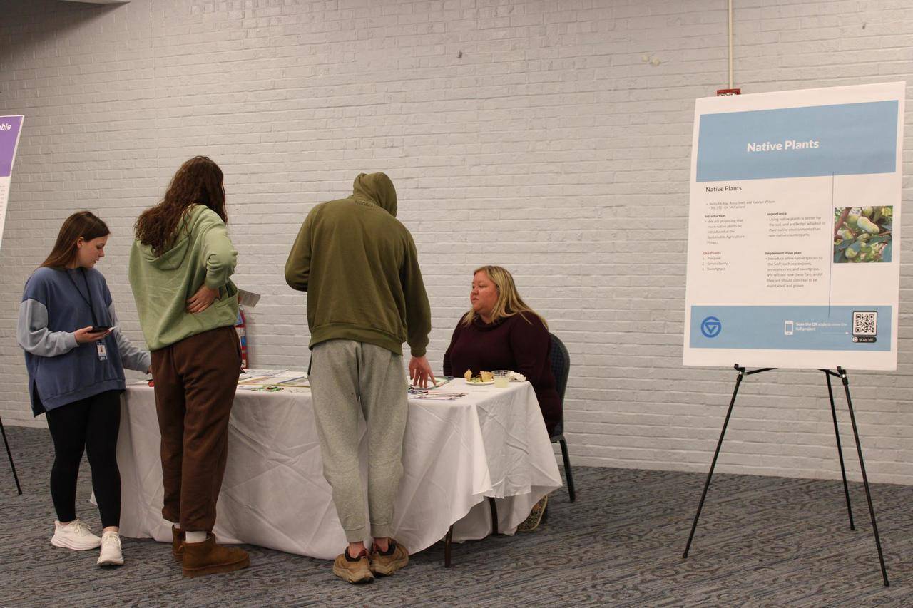 attendees talking to a presenter at their table
